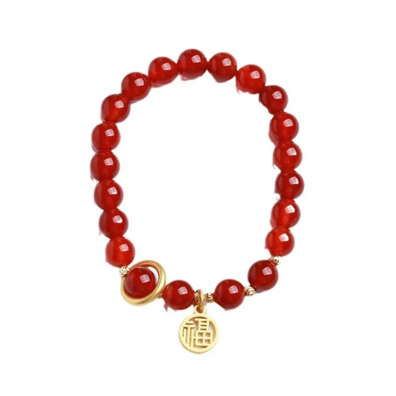 Natural red agate bead bracelet with woven design and blessing card on a neutral background.