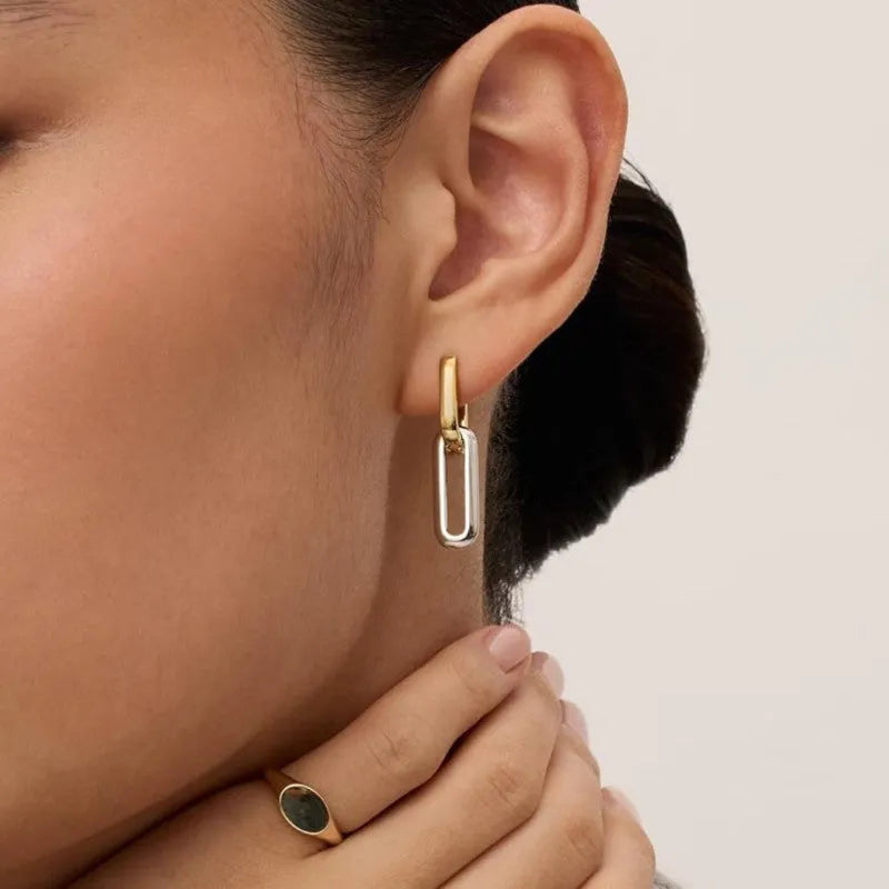 14K gold and silver two-tone geometric U-shaped earrings on a light background showing the copper core and metallic finish