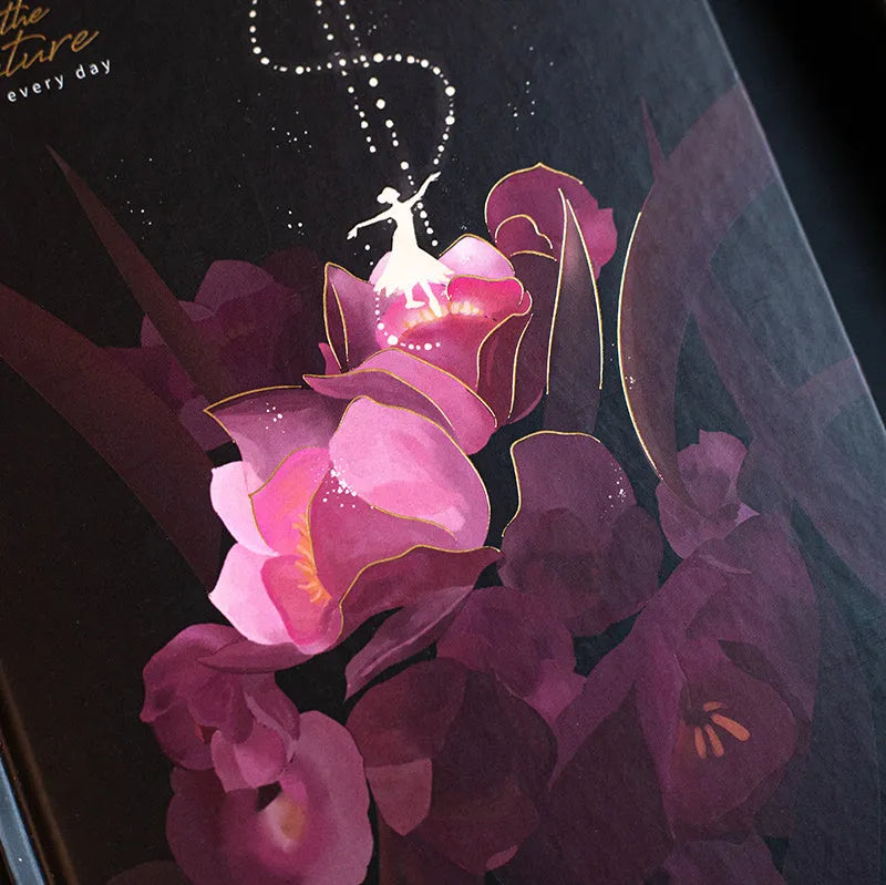 A5 size notebook with a luminous reflective cover, open to show internal pages with colour illustrations.