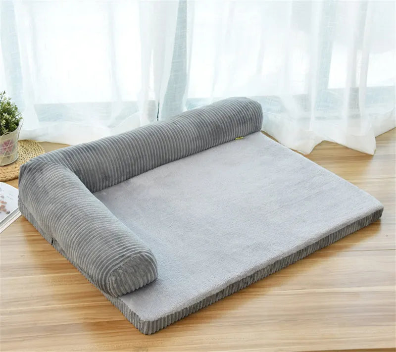 A corduroy dog sofa bed with raised sides in a grey colour, shown on a wooden floor.