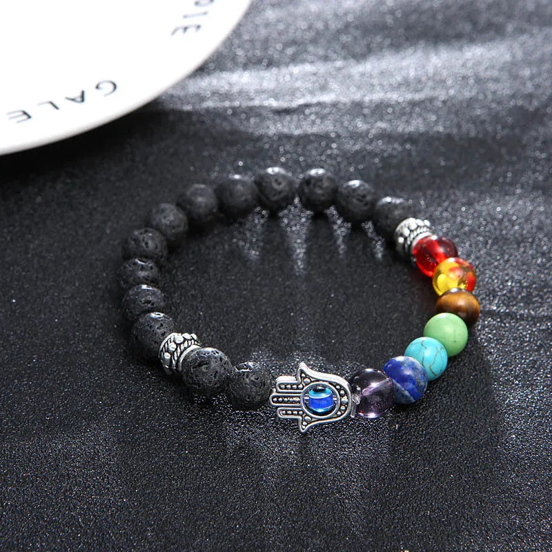 Volcanic rock and blue eyes palm seven chakra hand chain on a neutral background