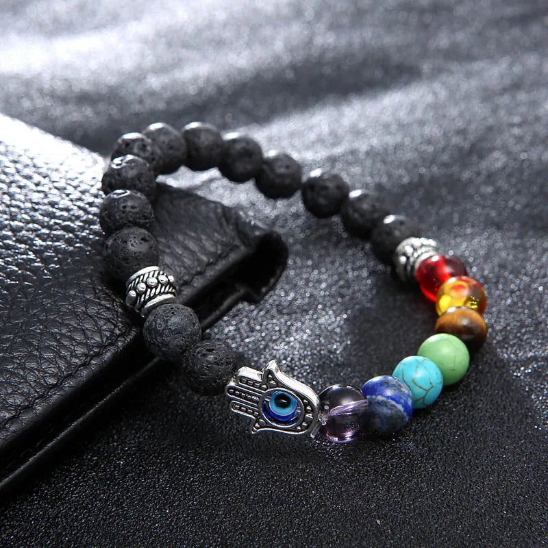 Volcanic rock and blue eyes palm seven chakra hand chain on a neutral background