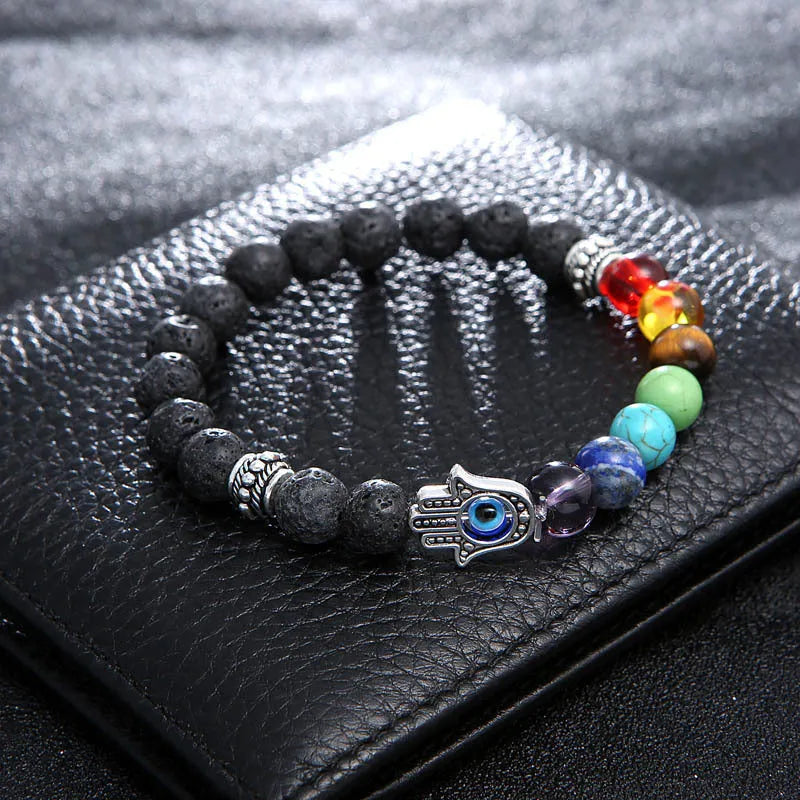 Volcanic rock and blue eyes palm seven chakra hand chain on a neutral background