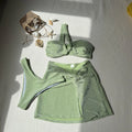 Women's light green one-shoulder glossy swimsuit top with matching bottoms and skirt