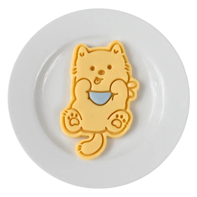 Plastic cartoon biscuit mould showing three-dimensional pet puppy designs including one with a birthday hat