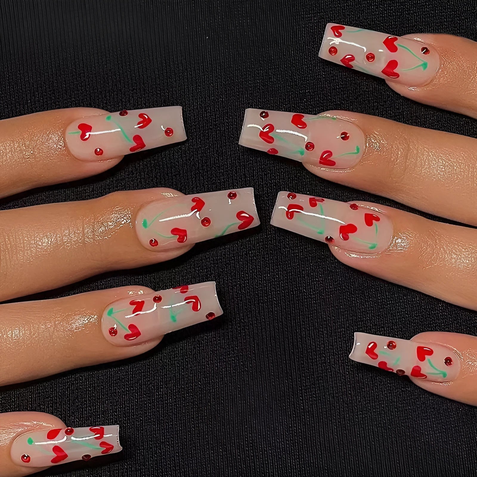 Pack of 24 red French love themed nail art stickers with small cherry and diamond designs, includes glue.