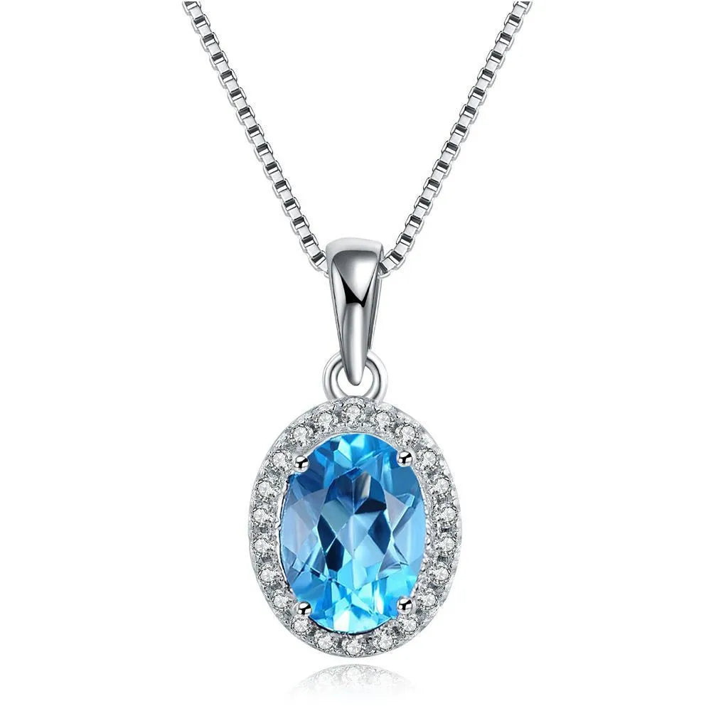 Four-piece sterling silver jewellery set with blue topaz gems showing geometric necklace, earrings, ring, and pendant