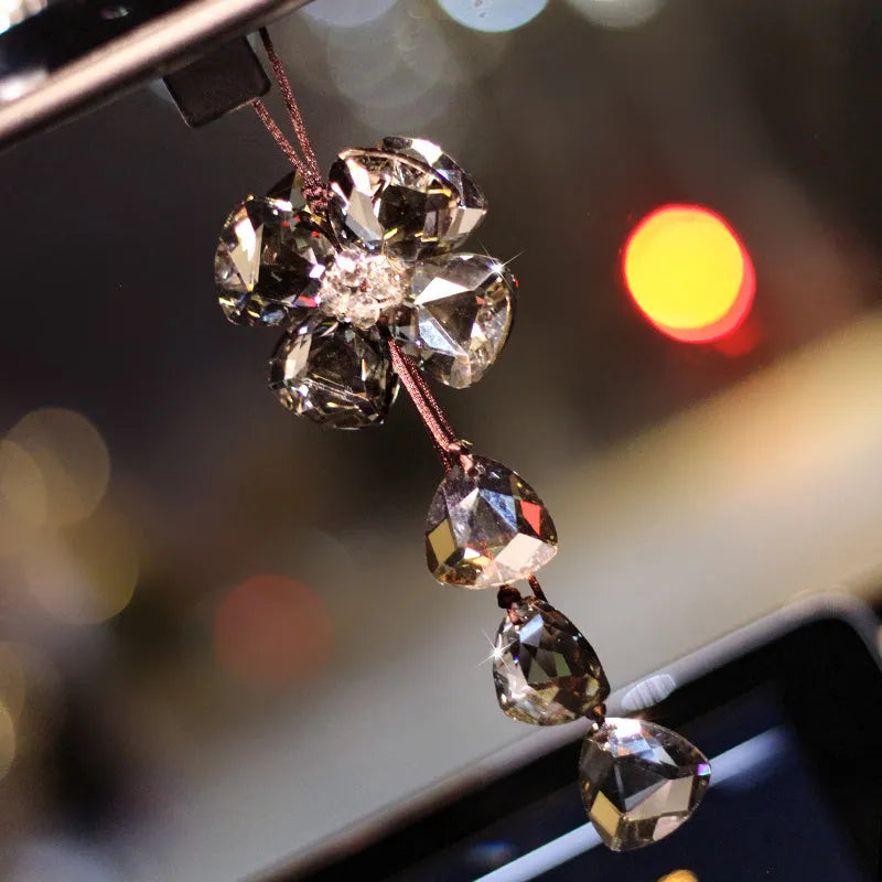 Crystal four leaf clover car pendant hanging, approximately 20 cm long, on a transparent background.