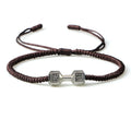Woven cord bracelet with dumbbell alloy charm in black gold finish on white background