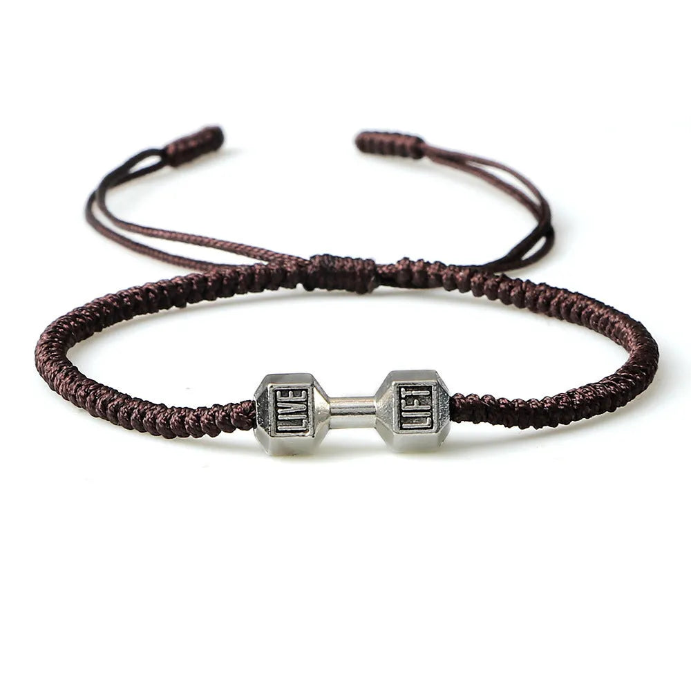 Woven cord bracelet with dumbbell alloy charm in black gold finish on white background