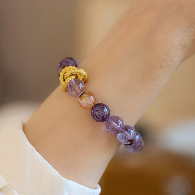 Purple cornucopia crystal bracelet with nine purple lucky charms on wrist