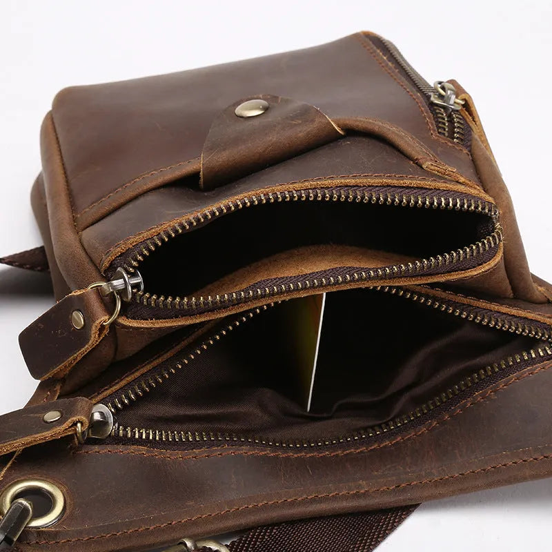 Men's brown Crazy Horse leather retro satchel bag with flap closure on a table.