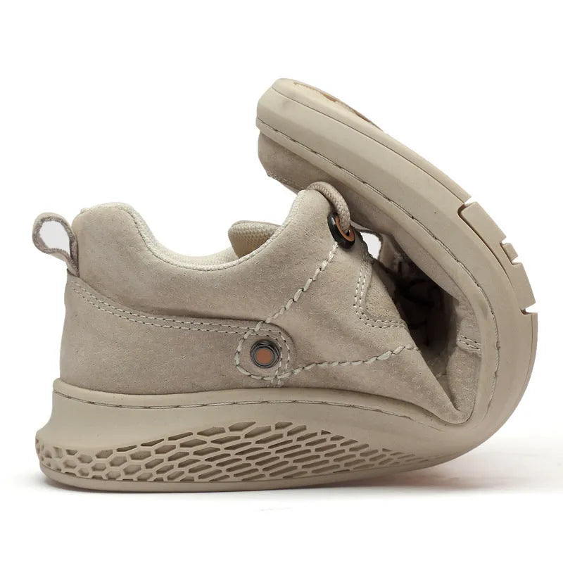 Men's brown leather sports shoes with suede finish and anti-skid plastic sole on concrete background