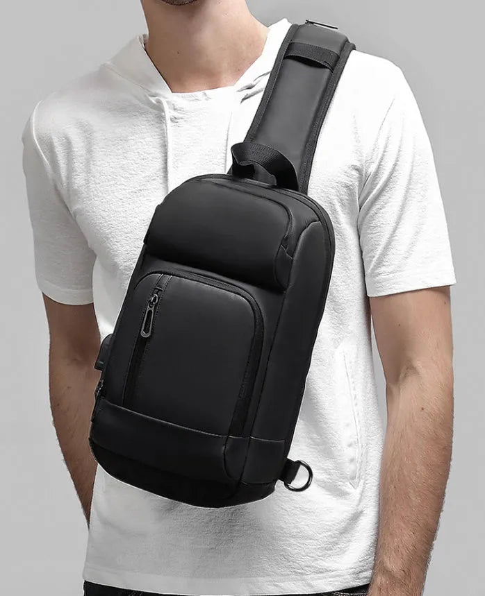 Black PVC outdoor shoulder bag with adjustable strap and internal laptop compartment