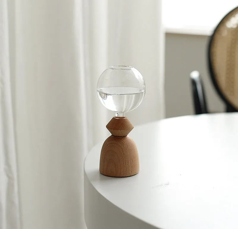 Small clear glass bubble vase on a wooden base, shown in conical bottom and arc bottom styles.