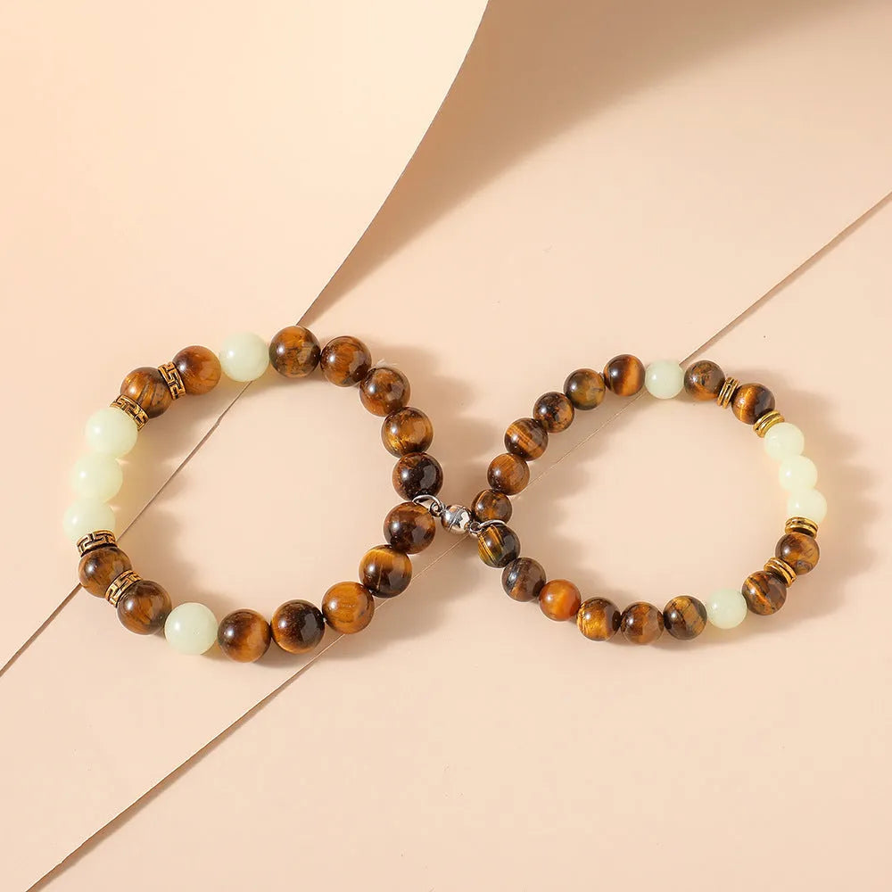 A pair of amber-coloured geometric resin bracelets with a luminous glow, shown together.