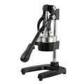 Black cast iron manual citrus juicer with stainless steel strainer on a kitchen counter.