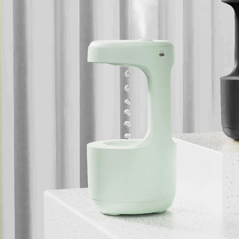 White anti-gravity humidifier with LED clock display emitting mist on a wooden desk.