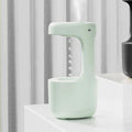 White anti-gravity humidifier with LED clock display emitting mist on a wooden desk.