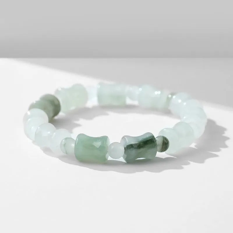 Simple beaded bracelet with chalcedony and coconut shell beads, diamond jade piece, and safety lock.