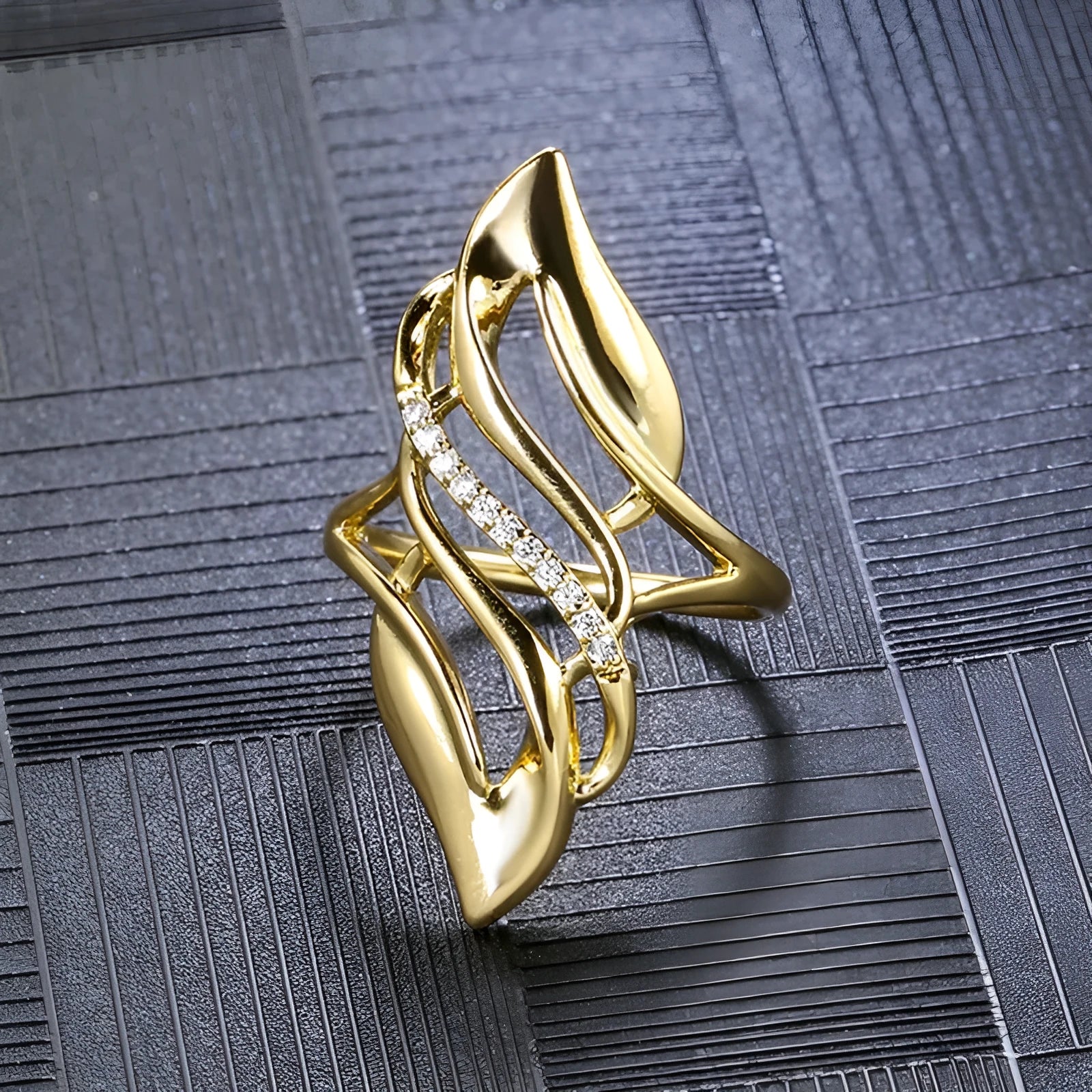 Women's gold-colour ring with exaggerated curved design on finger, showing profile and zircon finish