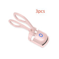White USB rechargeable heated eyelash curler with dual temperature settings shown on a pink background.