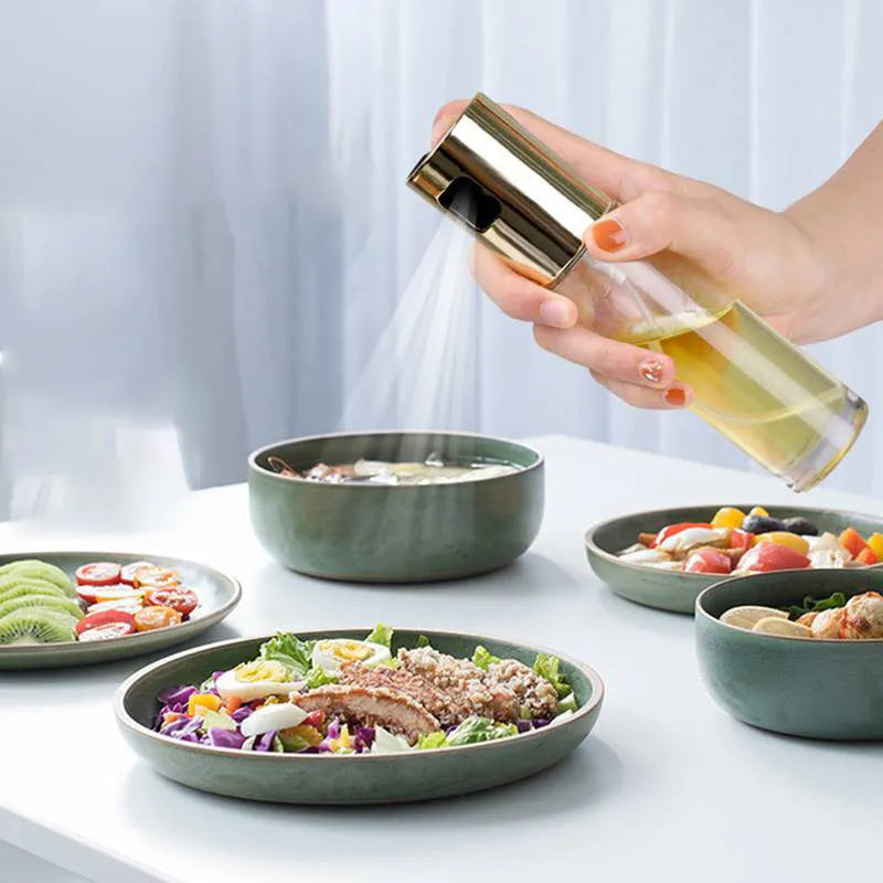 Gold ABS and glass oil and vinegar spray bottle with push-type pump, 17.5cm tall.