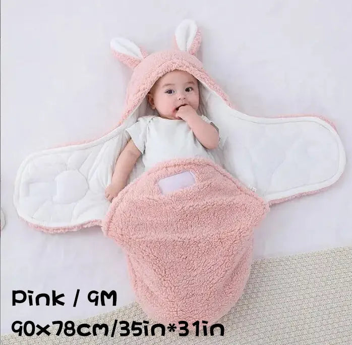 A baby wearing a soft grey fleece sleeping bag with hook-and-loop shoulder straps.