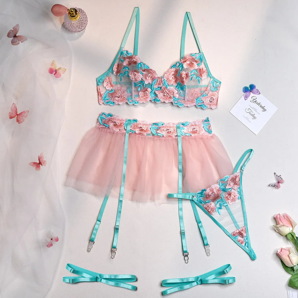 Pink embroidered women's bikini set with a matching mesh pettiskirt laid flat.