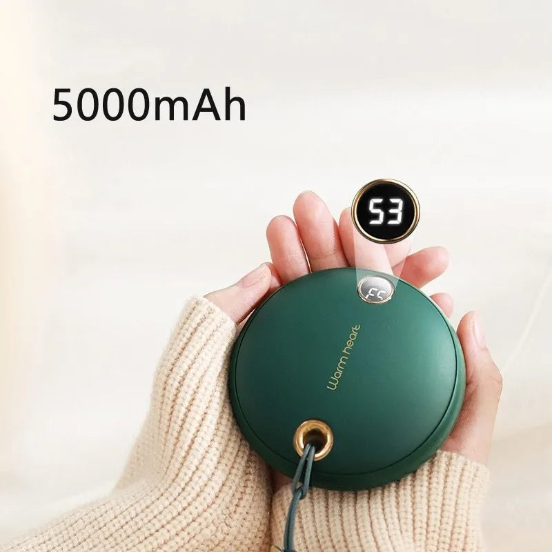 Green, pink, or white square 5000mAh hand warmer power bank with digital display next to charging cable.