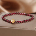 Red stone bead string bracelet with yellow flower accessories on wrist