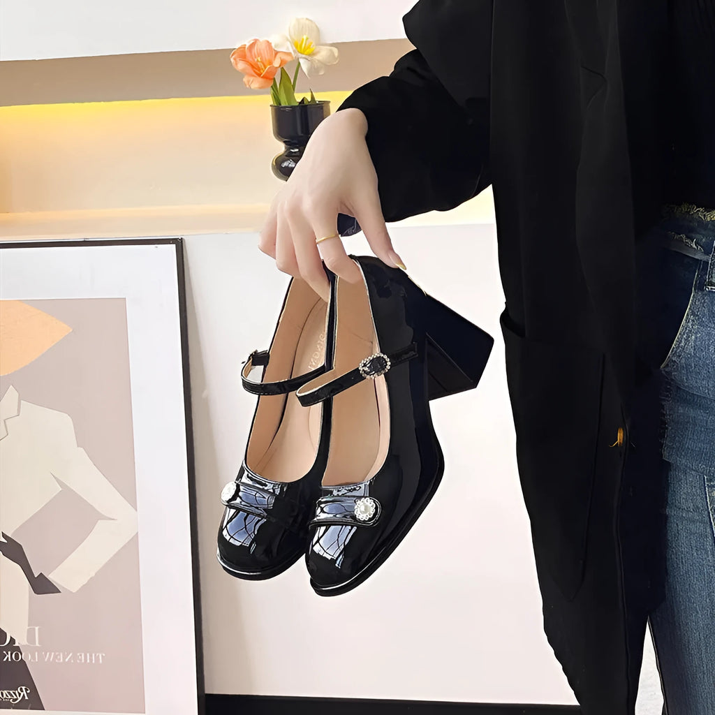 Women's black patent leather chunky heel sandals with round toe and buckle fastening.