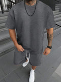 Men's short sleeve top and shorts suit in a printed pattern, shown in a sport leisure style.