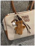 Soft plush brown bear doll pendant keychain hanging on a bag, with a cute bear/piglet animal pattern