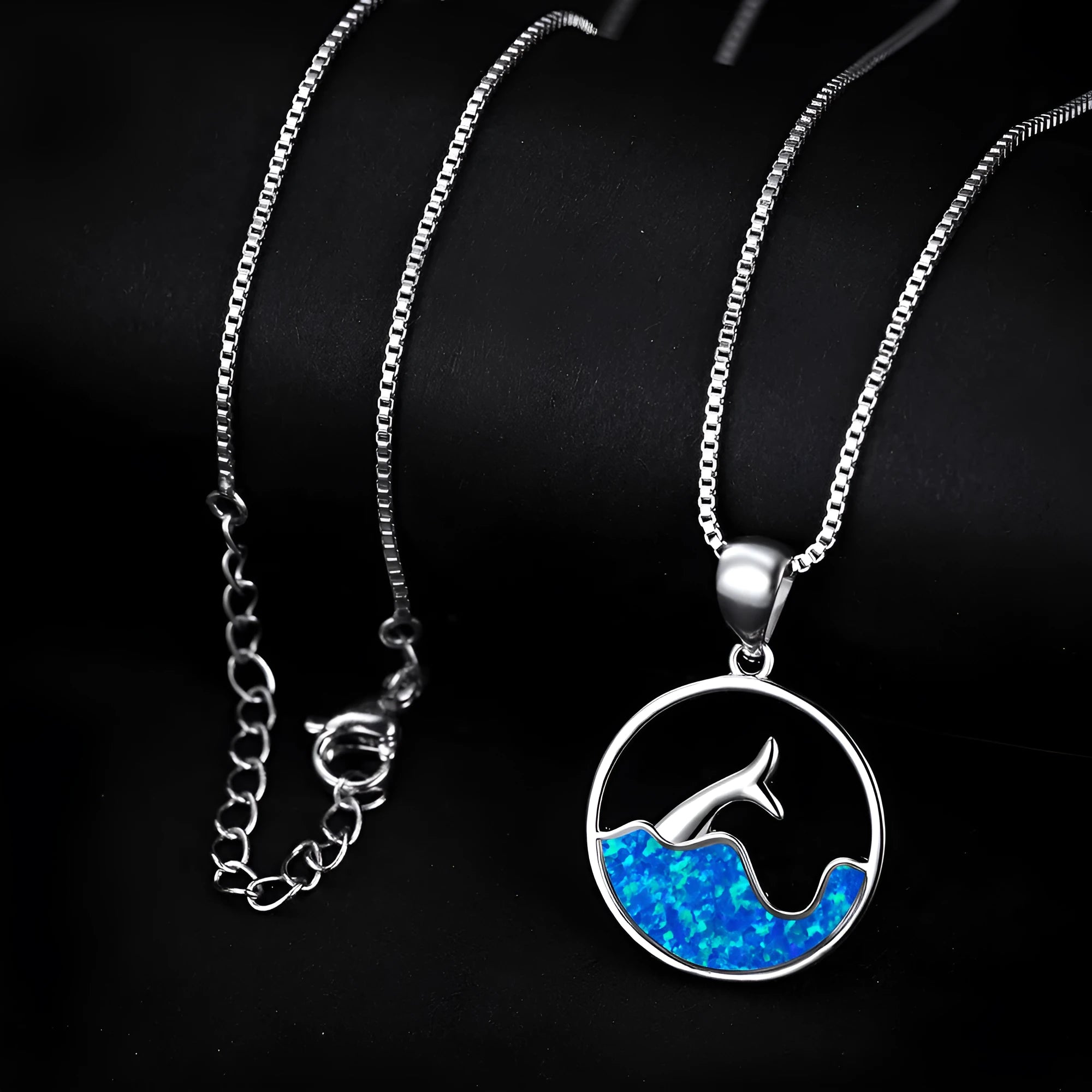 Geometric fishtail pendant necklace with a round blue opal on a silver-toned chain.
