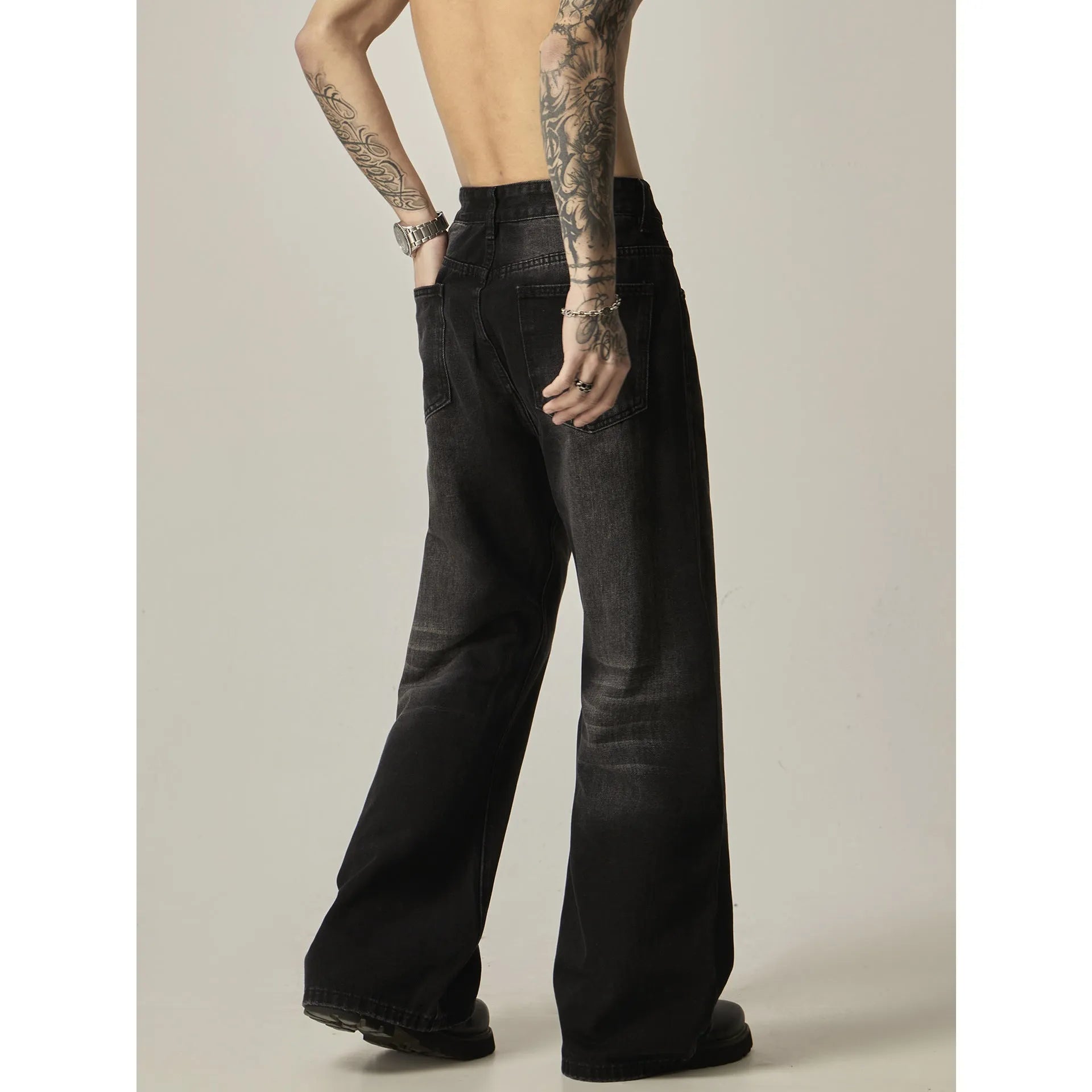 Black loose-fit straight-leg retro jeans with zipper fly on a plain background.
