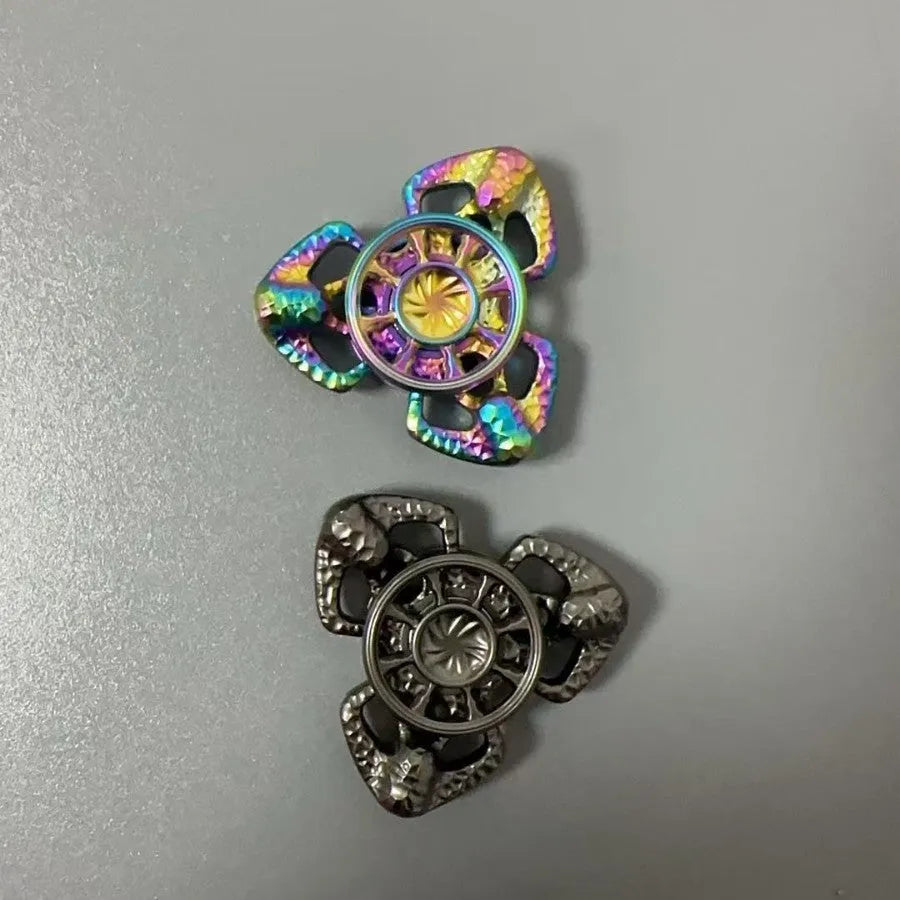Flame Butterfly metal alloy rotating gyro spinner fidget toy on a flat surface.