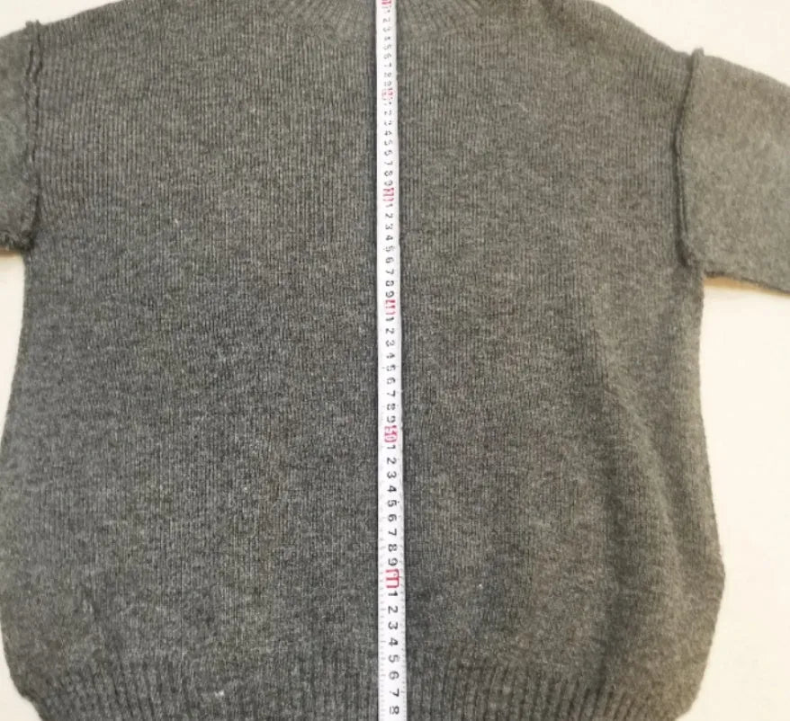 Women's dark grey knit co-ord suit with side-slit sweater top and matching trousers.