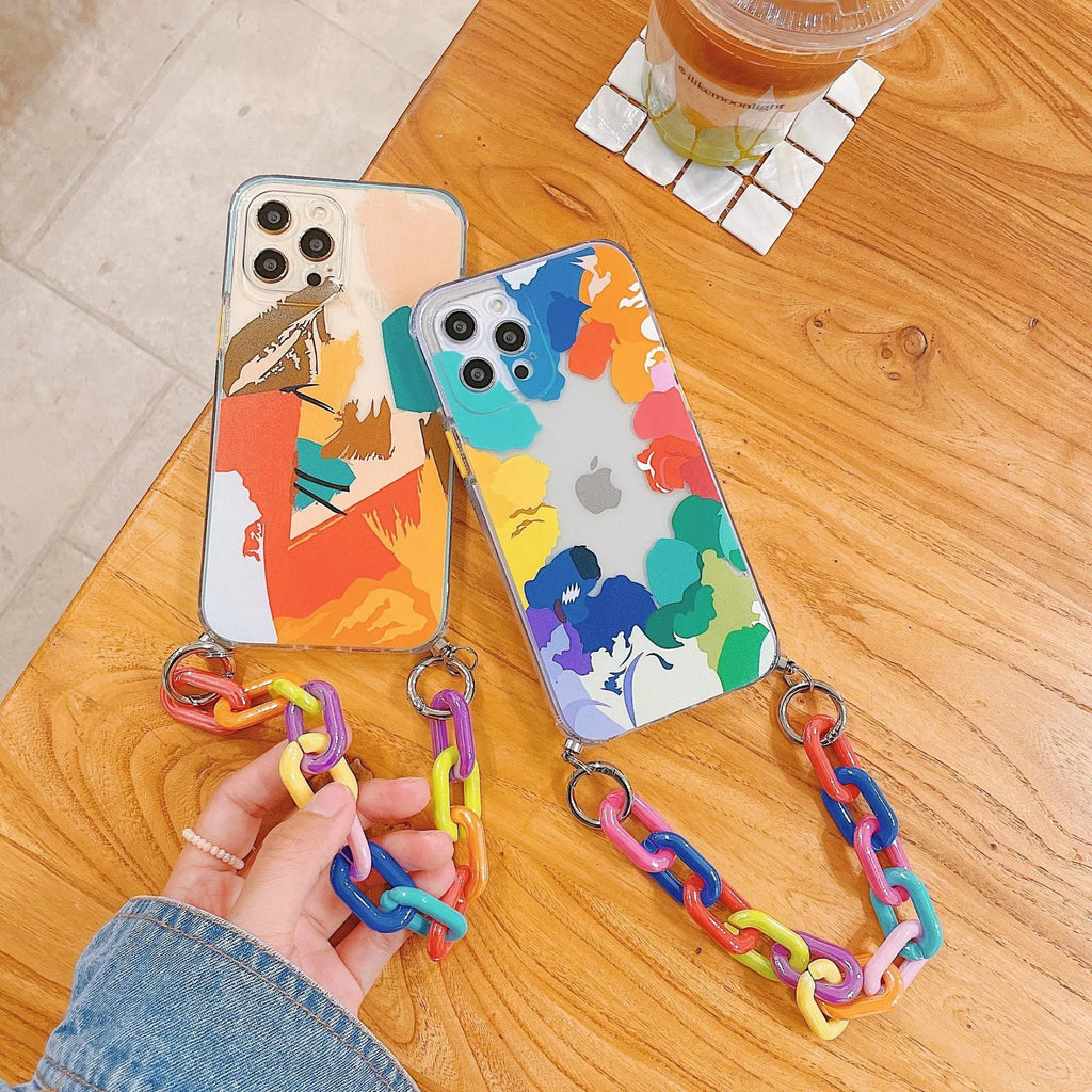 Pink iPhone case with a graffiti design and a white wrist strap attached.
