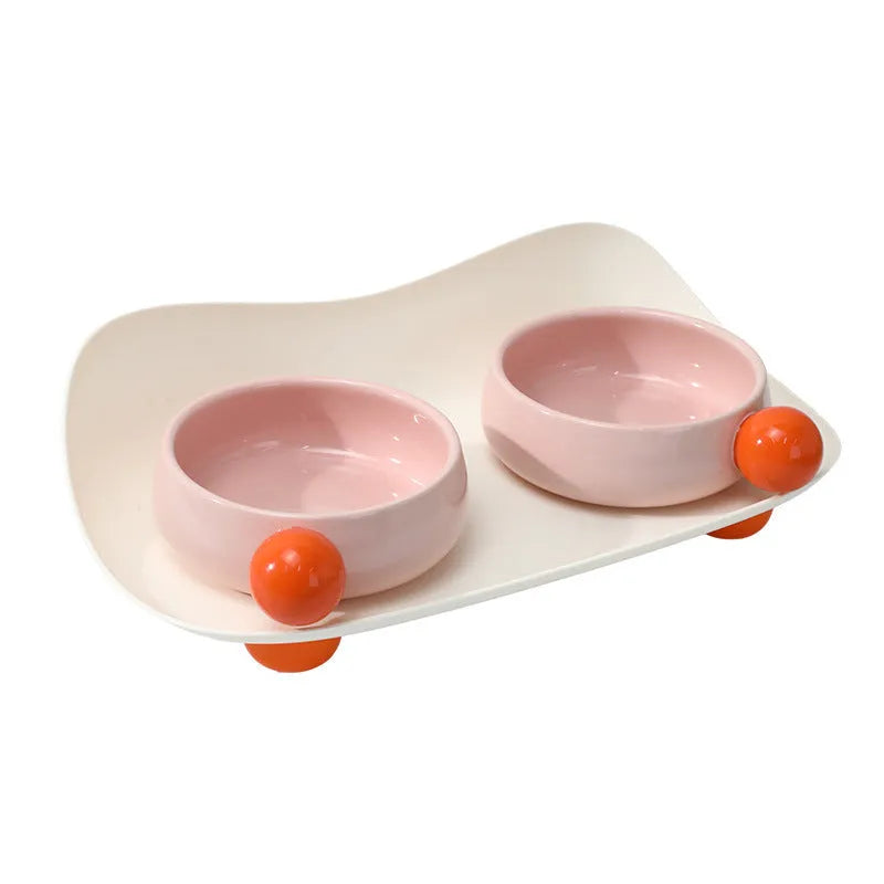 Raised ceramic pet feeding bowl set with two bowls in pink yellow colour on a non-slip base.