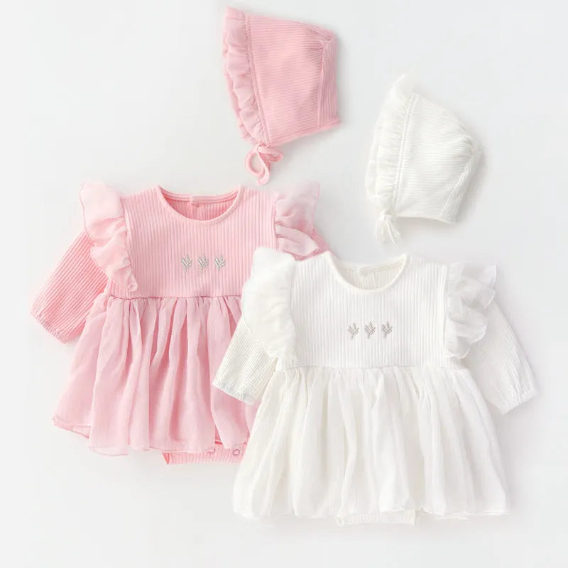Baby girl wearing a fluffy cotton princess dress in pink, available in red and white, sizes 59cm to 80cm.
