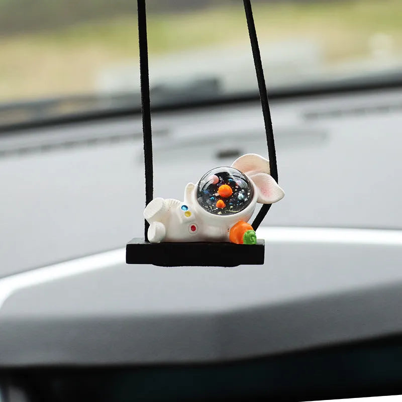 Resin astronaut car pendant showing cartoon astronaut designs including telescope, red flag, and radish variations