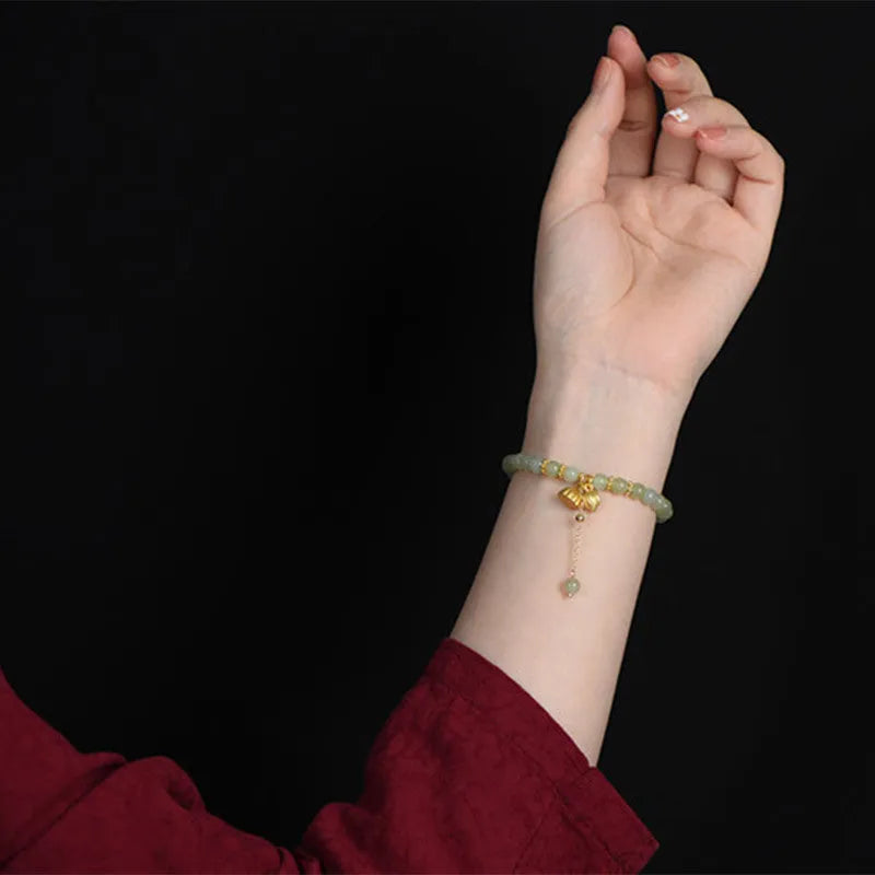 Natural Hetian Jade bracelet with Fu character detail on 6mm beads in a sunny water colour.