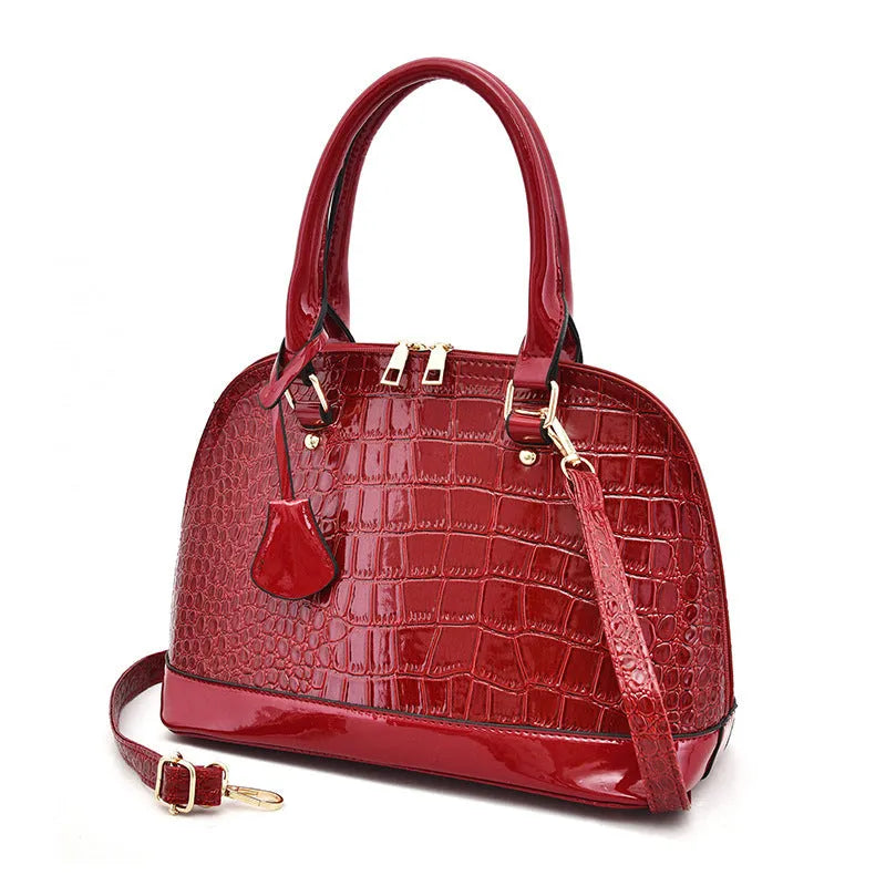 Women's shiny PU leather crossbody shoulder bag showing black, brown, and red colour options with 22x30x15cm dimensions