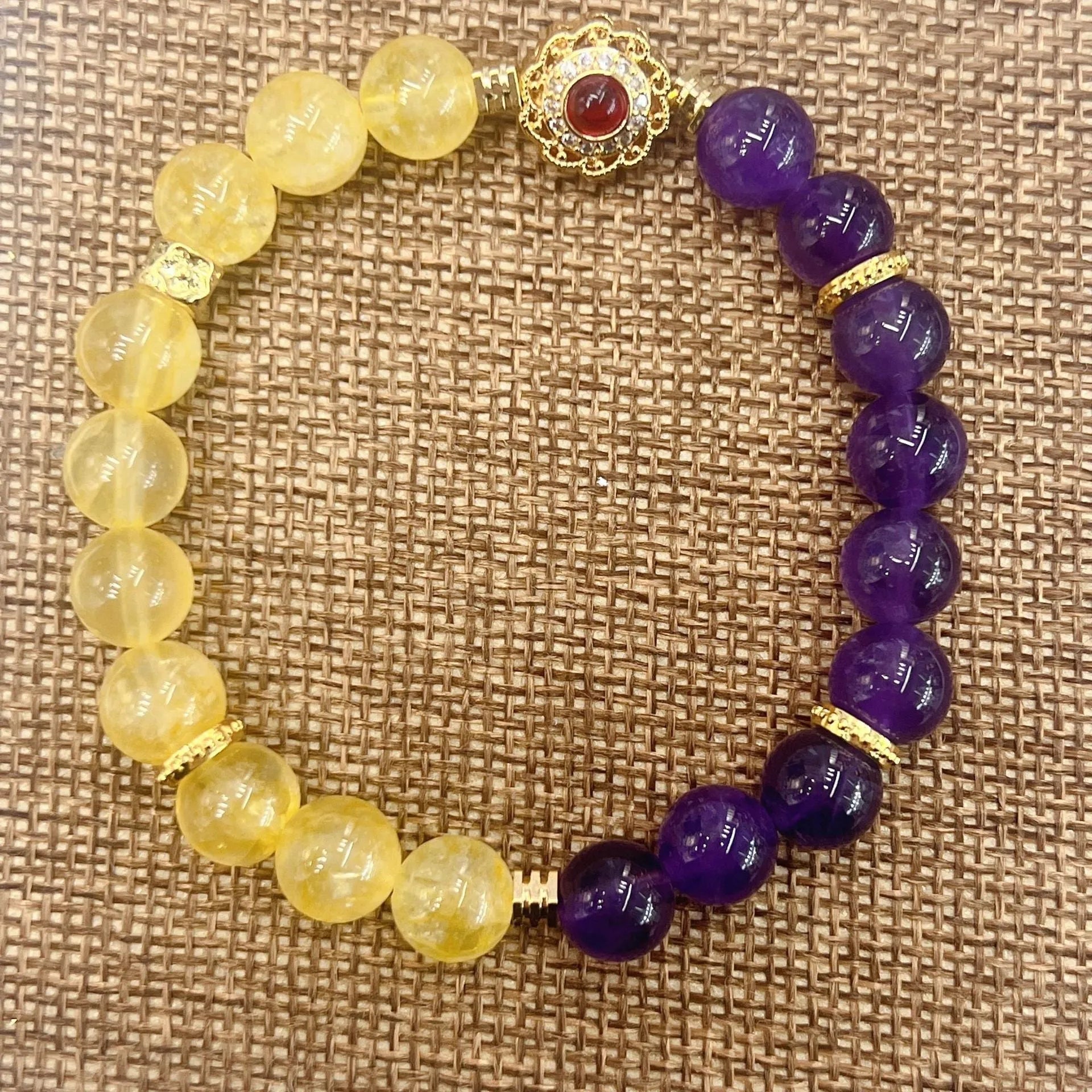 Handmade women's yellow and purple amethyst crystal bracelet showing manual craftsmanship detail