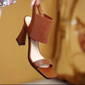 Women's black high heel sandals with elastic straps, showing side profile on a plain background.
