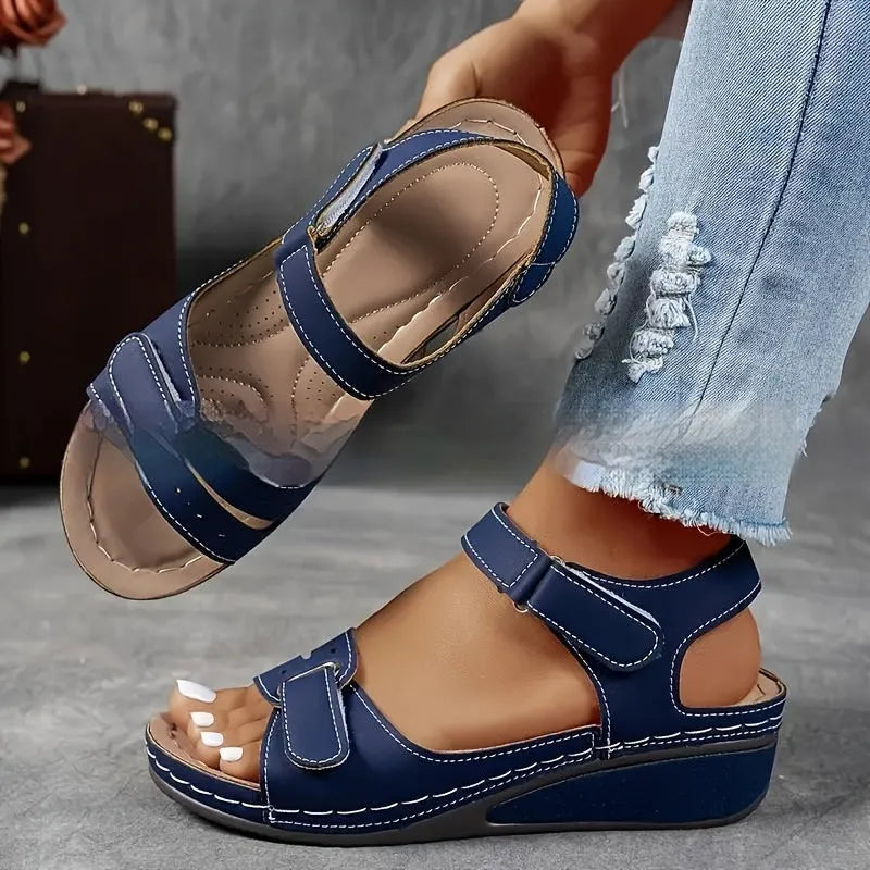 Beige wide fit sandals with thick composite sole and adjustable Velcro straps on a white background.