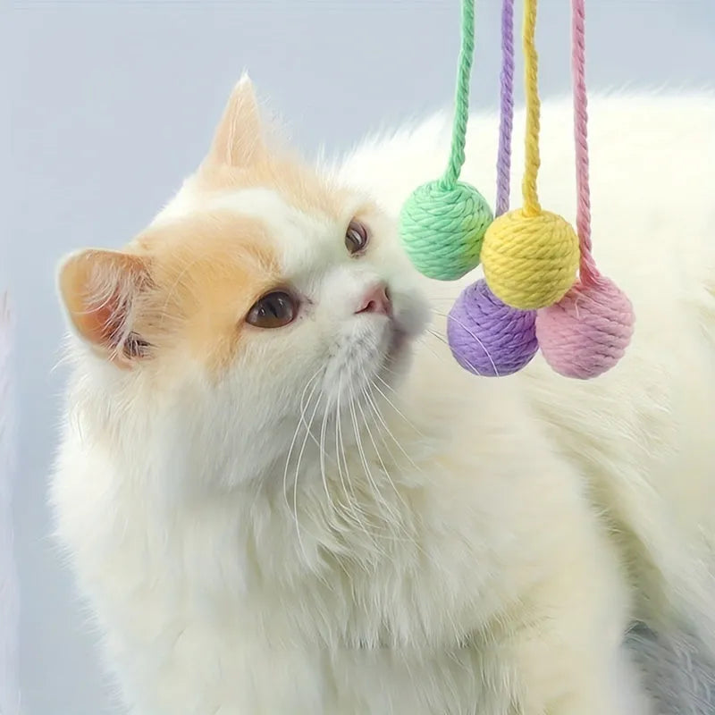Cat toy ball with rope handle in green, pink, purple or yellow colours with internal bell
