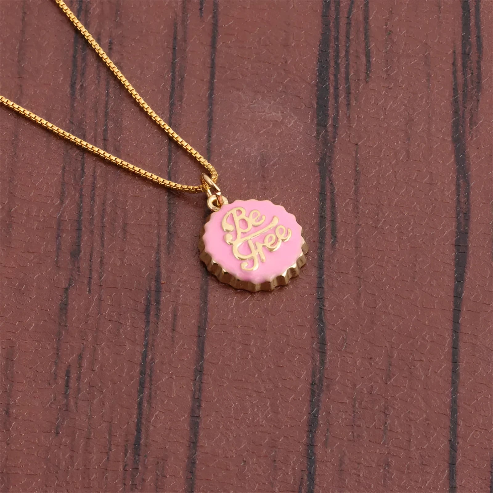 Gold-plated bottle cap pendant on a 40 cm copper box chain necklace, shown in various colours.