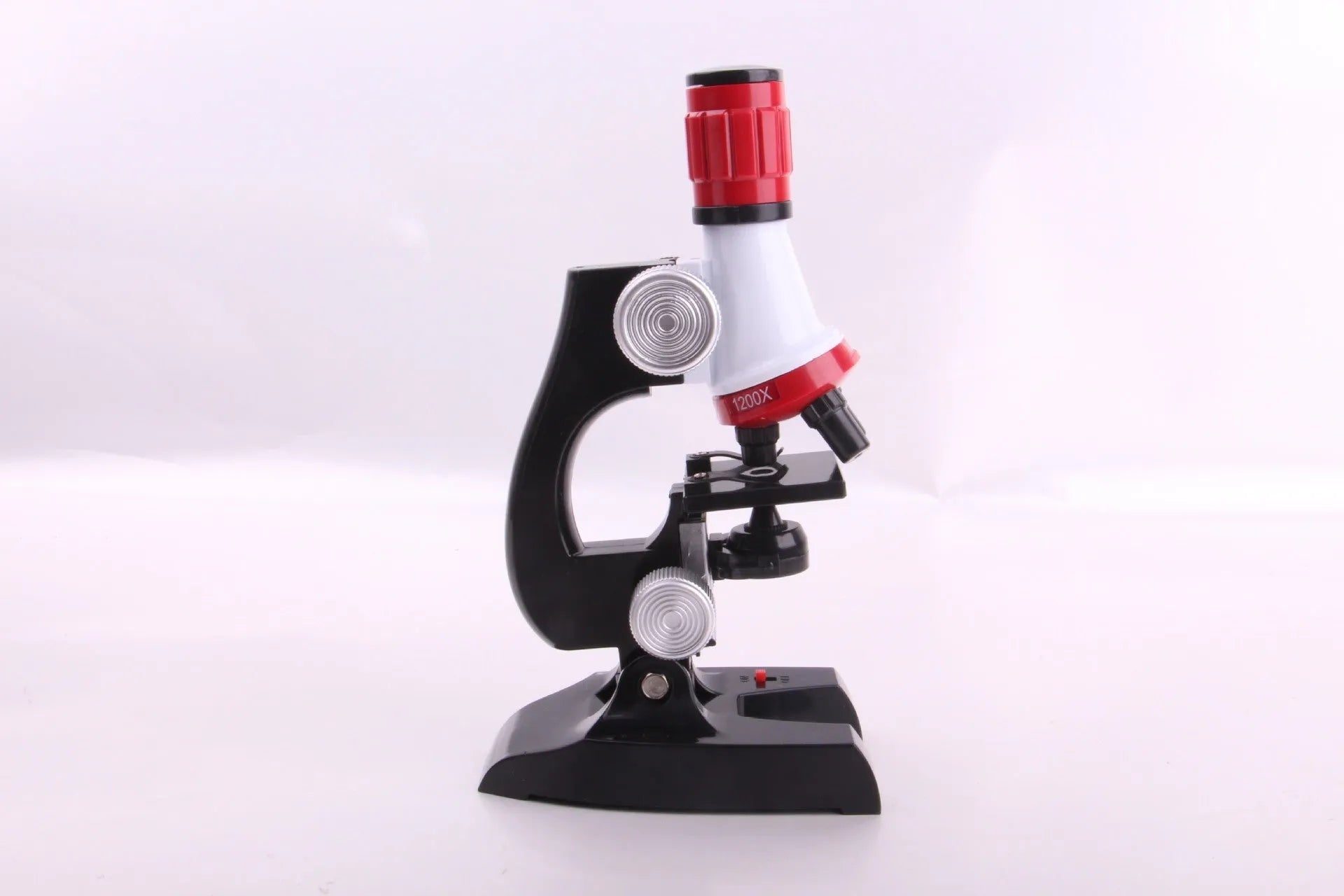 Child biological microscope with LED light, three objective lenses, and coarse focus knob on white background